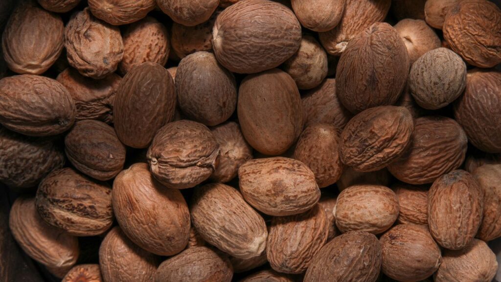 Whole nutmeg seeds with textured shells used for cooking and flavouring
